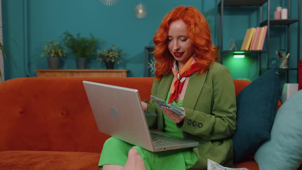 Smiling Happy Woman Counting Money Cash and Use Laptop Pc Calculate Domestic Income Earnings at Home