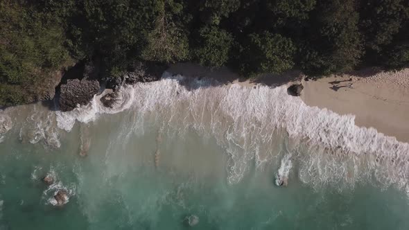 Aerial View of Tropical Beach with Azure Blue Water and Foaming Ocean Waves