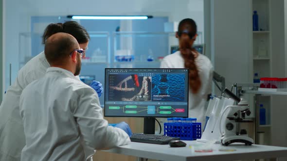 Group of Scientists Working in Modern Equipped Laboratory Pointing on Computer