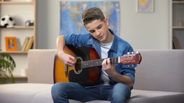 Cheerful Caucasian Teenager Playing Guitar, Enjoying Favorite Hobby, Leisure