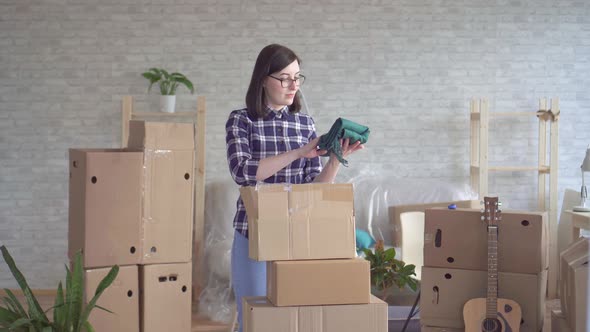 Portrait Young Woman in Plaid Shirt Unpacking Boxes Moving To New Home