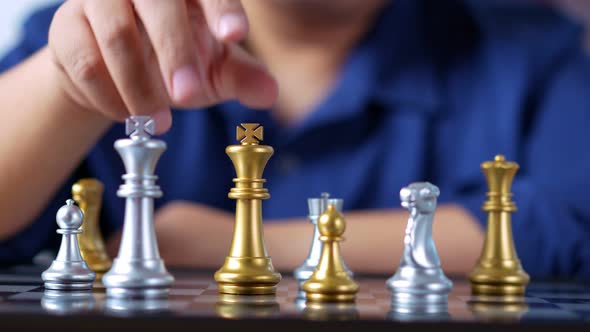 Close up of hands of a businessman moving king golden chess to surrender with an opponent the chess
