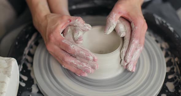 Top View of Mother and Son Hands Making Ceramic Pot on Pottery Wheel