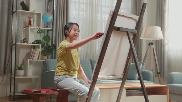Asian Artist Girl Holding Paintbrush And Painting On The Canvas