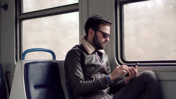 Man In Sunglasses Using Mobile Phone On Train. Businessman Chatting On Mobile Phone Sending Message