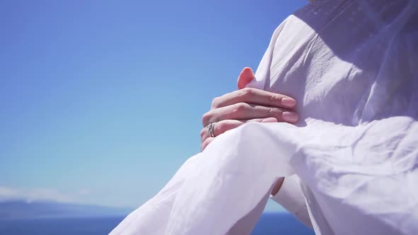 Beautiful Woman Holds Her Hand on a White Shirt on a Windy Day, Slow Motion. Girl Model on Vacation