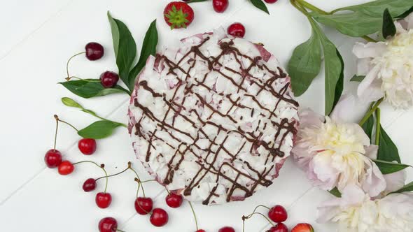 White Cake with Red Ripe Berries on the White Wooden Table