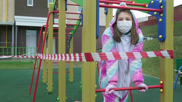 Young Girl in a Protective Mask at the Playground.