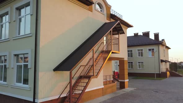 Footage of modern daycare school building with emergency fire exit staircase.