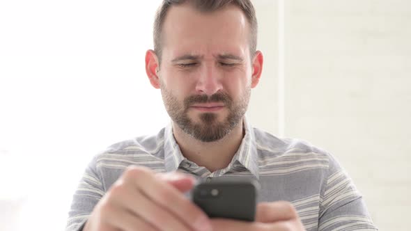 Close Up of Man with Headache Using Smartphone