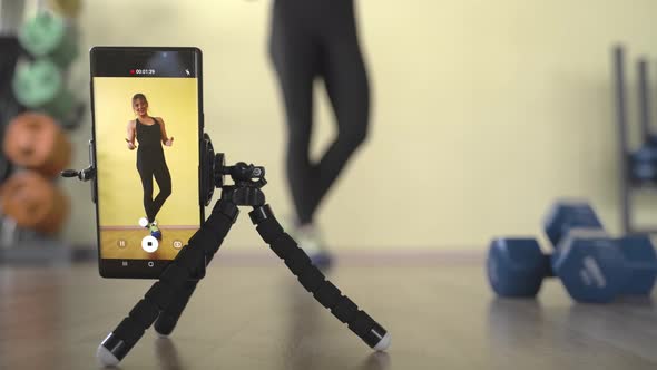 Fitness Training Online. Woman Conducts Training on the Internet Through a Smartphone.