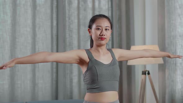 Asian Trainer Female In Sports Clothes Speaking And Stretching While Teaching Exercise At Home