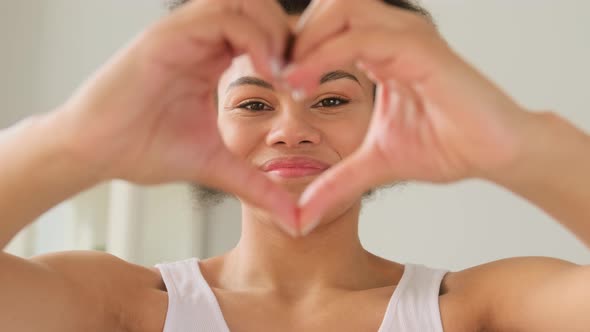 African american black woman showing hands sign heart shape. Demonstration of love.