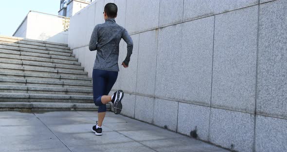 Fitness sports woman running up stairs in city