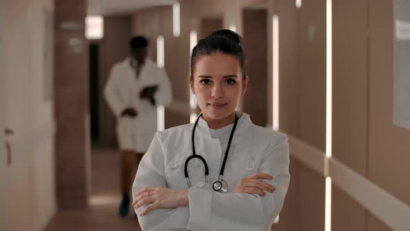 Smiling Female Doctor Looking at Camera in Hospital Hallway