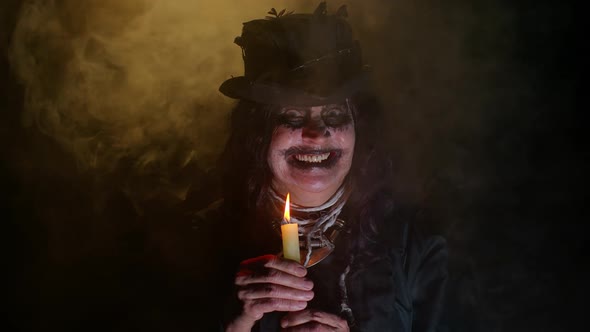 Frightening Creepy Senior Woman with Halloween Witch Makeup Looking at Candle Conjure Hex Wiz