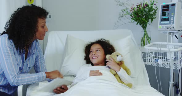 Front view of African american mother talking with her son in ward at hospital 4k