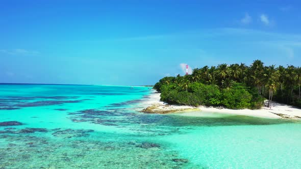 Aerial above seascape of exotic lagoon beach holiday by blue green water and white sandy background 