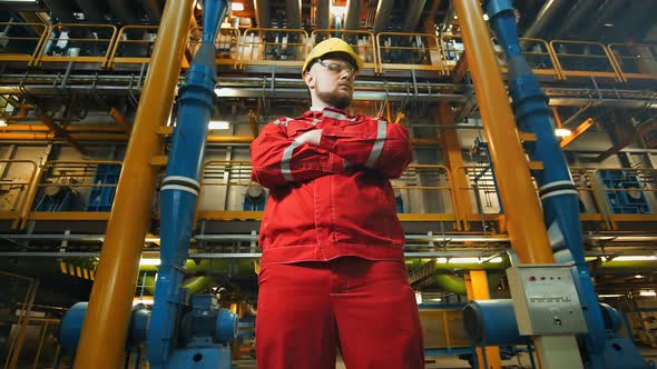 Factory Worker in Uniform Posing on Industrial Plant