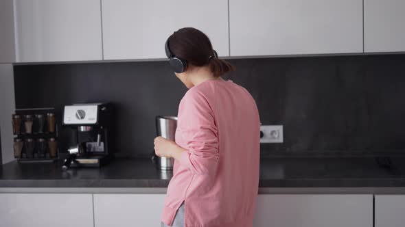 Portrait of Girl Posing in Kitchen Listening to Songs in Headphones