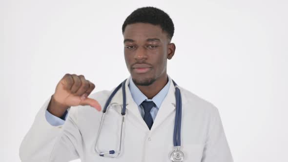 Thumbs Down Gesture By African Doctor on White Background