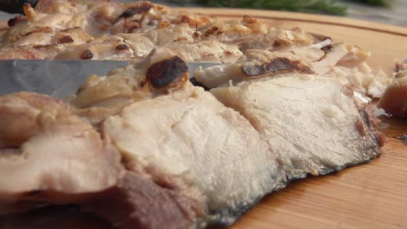 Close-up of Grilled White Fish Fillet Cut with a Knife on the Wooden Board