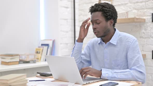 African Man Having Headache While Working