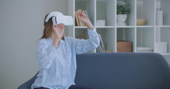 Young Girl in Virtual Reality Headset Scrolling in Air at Home Technology Concept. Young Cheerful