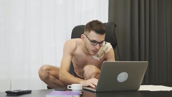 Broker sitting on squat at his office and reading news on internet