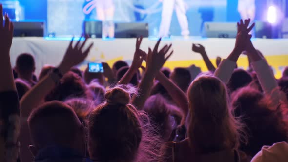 Young Music Fans Having Fun and Jumping at a Concert