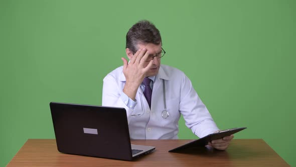 Mature Handsome Man Doctor Against Green Background