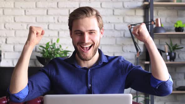 Happy young businessman is analizing financial documents from home during self isolation on laptop.