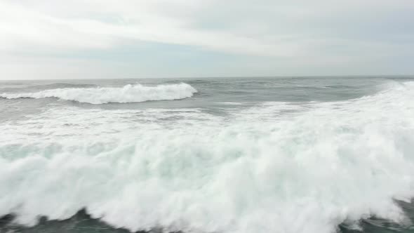 Aerial Motion Along Beautiful Ocean Waves Under Cloudy Sky