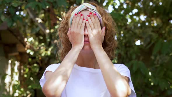 Young Adult with Hands Covering Face Discovers Them Smiling