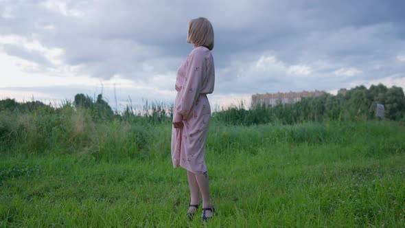 Wide Shot of Relaxed Happy Trans Woman in Pink Dress with Man and Woman Chinese Tattoo on Leg