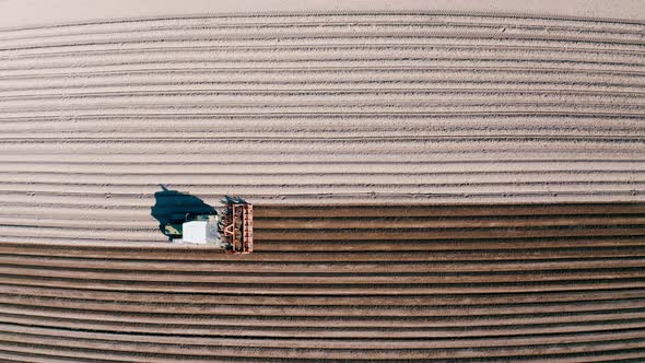 Tracking Shot Of Farmer Preparing Asparagus Field With Tractor