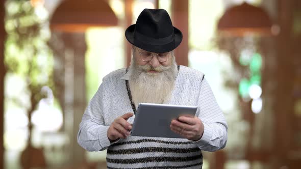 Old Retired Grandpa Talking with Someone Online Using Tablet Pc