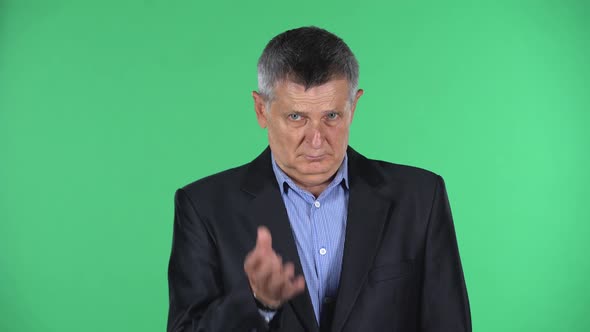 Portrait of Aged Man Looking Straight and Waving His Hands in Indignation Isolated Over Green