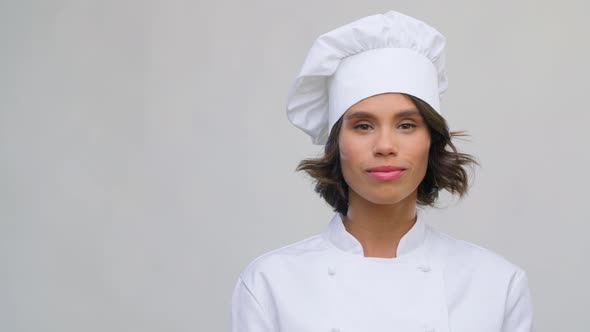 Portrait of Smiling Female Chef in Toque Over Grey
