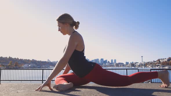 Fit Female Yoga Practitioner Doing Ground Based Yoga Exercises At Lake Union Waterfront