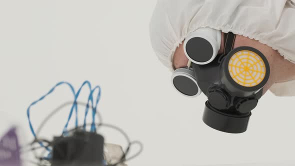 Man in white chemical protection suite is checking up electronic wires. Close-up