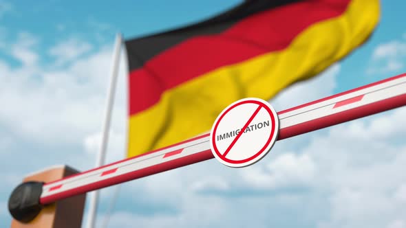Opening Boom Barrier with Stop Immigration Sign Against the German Flag alt