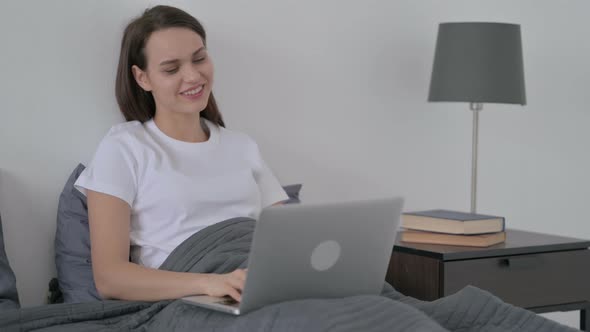 Woman Doing Video Call on Laptop in Bed