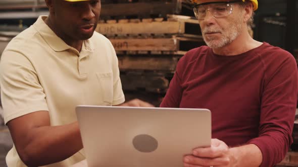 Workers discussing over laptop