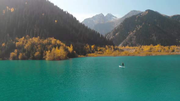 Man Is Paddling on Sup Board in the Mountain Lake