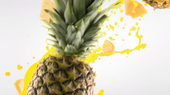 Pineapple with Slices Falling on White Background