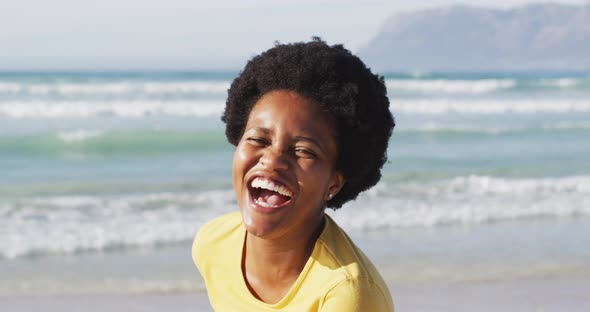 Portrait of happy african american woman on sunny beach