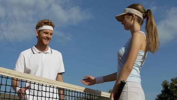 Young Couple Meeting on Tennis Court, Handshaking After Game, People Flirting