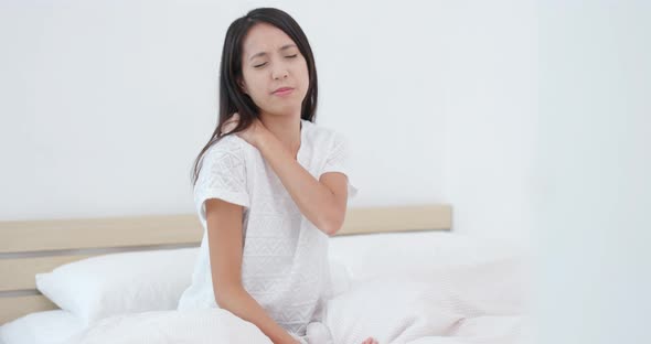 Woman feeling back pain and tired on bed 