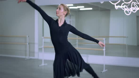 Graceful Slim Smiling Ballerina Doing Arabesque Steps and Looking at Camera